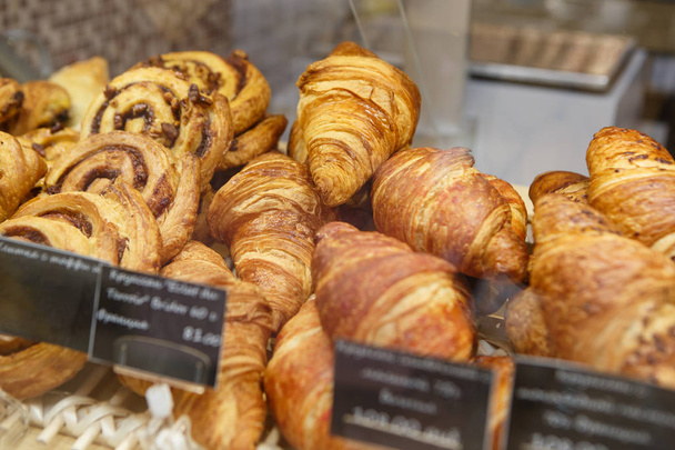 Fresh baked croissant pastry on sale in cafe.Empty price tag frames.Buy tasty bakery product for coffee break.Sweet dessert food.Macro,close up. - Foto, imagen