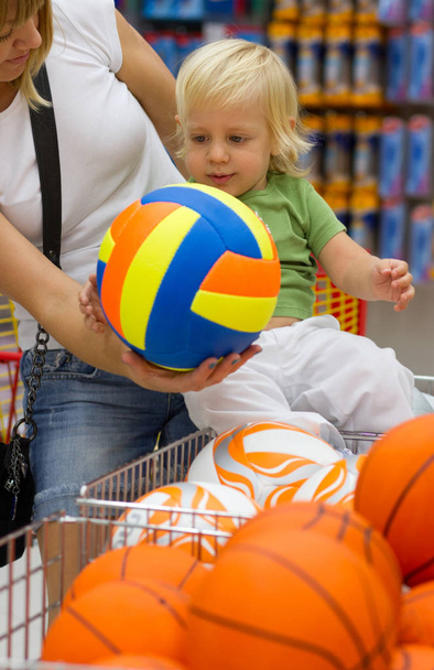 Leuke kleine blonde jongen en zijn jonge moeder in winkelen naar het winkelcentrum - Foto, afbeelding