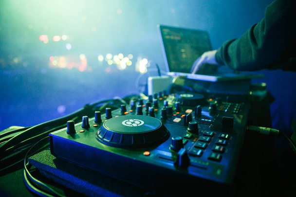 MOSCOW - 30 NOVEMBER,2016: Disc jockey mixing music on digital midi turntable controller at hip hop party on stage in night club. fingers of DJ mixing tracks on mixer on concert in nightclub - Fotografie, Obrázek