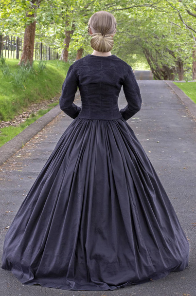 Viktorianische Frau in schwarzem Ensemble im Garten - Foto, Bild