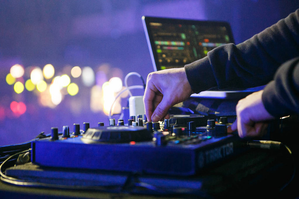 MOSCOW - 30 NOVEMBER,2016: Disc jockey mixing music on digital midi turntable controller at hip hop party on stage in night club. fingers of DJ mixing tracks on mixer on concert in nightclub - Photo, Image