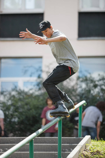 MOSCOW - 15 AUGUST, 2015: Outdoor aggressive rollerbladers  completion S3T contest. Young skater guy grinding handrail on skates. - Fotoğraf, Görsel