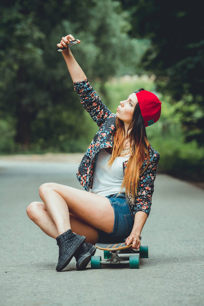 young beautiful fit  womanon  skateboard taking selfie  in park - Foto, Bild