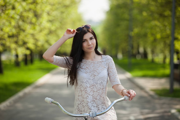 春の公園で自転車と若い白人の女の子 - 写真・画像