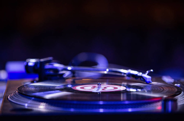 KIEV-11 JULY,2018: Retro Technics SL 1210 turntable player with old analog vinyl record on stage in night club.Professional club dj setup for playing techno music.Scratch tracks with turn table - 写真・画像