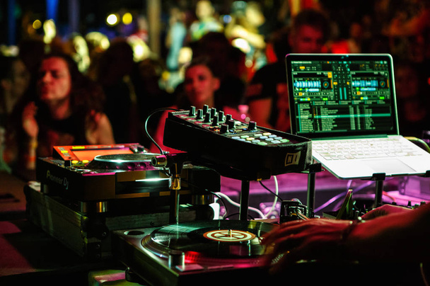 KIEV-4 JULY,2018: Professional dj equipment on stage in night club.Retro Technics vinyl player,Pioneer CDJ turntable,sound mixer and midi controller connected with Apple Macbook Pro notebook - Fotoğraf, Görsel