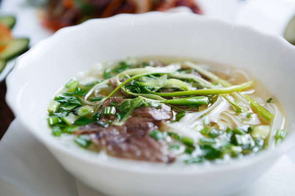 Delicious Vietnamese tradition restaurant food pho bo soup.Natural exotic food menu.Tasty Asian hot dish with beef meat & noodles served in bowl - Фото, зображення