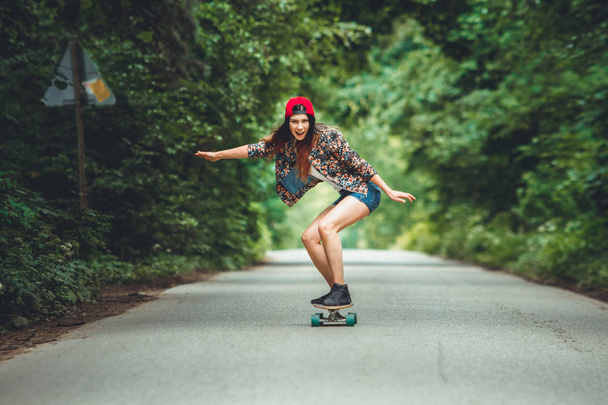young beautiful fit  woman on skateboard in park - 写真・画像