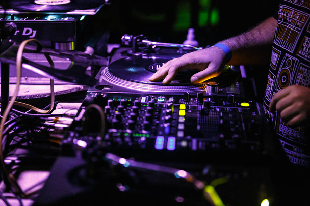 KIEV-4 JULY,2018: Hip hop dj scratches vinyl records with Technics SL-1210 turntables.Professional disc jockey audio equipment on concert stage in night club.Djs setup for techno music party  - Photo, Image