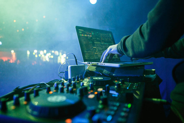 MOSCOW - 30 NOVEMBER,2016: Disc jockey mixing music on digital midi turntable controller at hip hop party on stage in night club. fingers of DJ mixing tracks on mixer on concert in nightclub - Fotoğraf, Görsel