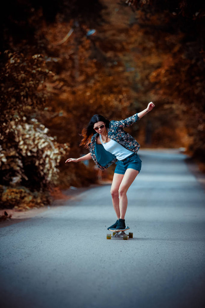 young beautiful fit  woman on skateboard in park - Fotoğraf, Görsel