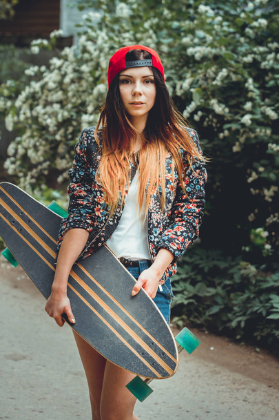 young beautiful fit  woman with  skateboard in park - Фото, изображение