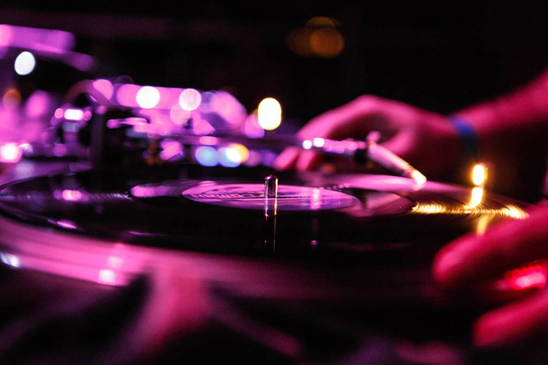 KIEV-4 JULY,2018: Retro Technics SL 1210 turntable player with old analog disc.Dj plays music with vintage turn table device on stage in night club - Foto, Imagem