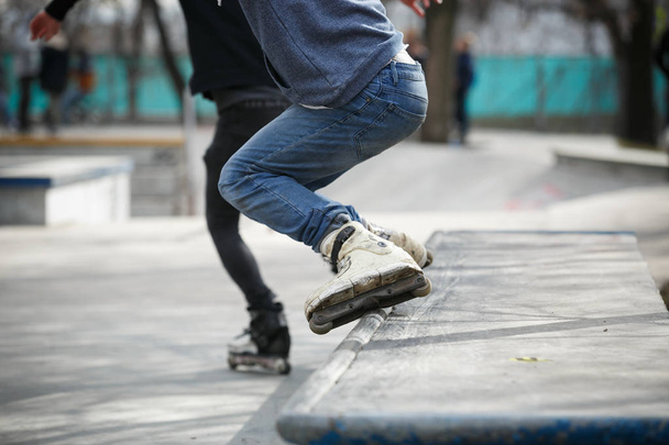 Moskau - 25. März 2017: Füße aggressiver Inline-Skater schleifen beim Streetskate-Contest auf extremen Inline-Rollschuhen im Outdoor-Skatepark mit Schiene - Foto, Bild