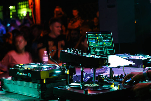 KIEV-4 JULY,2018: Party dj equipment on concert stage.Play and remix music with Traktor software installed on Apple Macbook Pro connected with Technics SL1210 turntables and Pioneer sound mixer - Photo, image