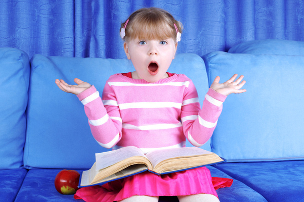 Surprised girl with apple and books - 写真・画像