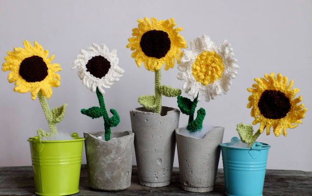 Amazing five flower vase on table make from craftsmanship by knit art from yarn, white and yellow sunflower with green leaves in jar so nice for decoration home, beautiful woolen flora in front view - Photo, Image