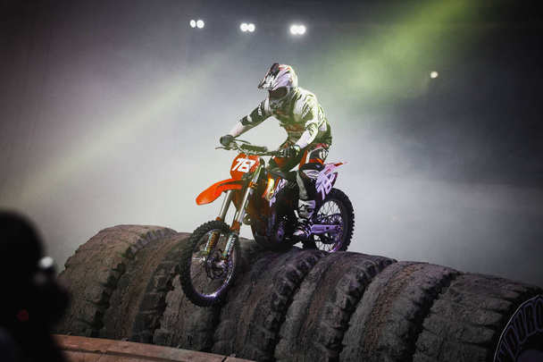 MOSCOW - 14 MARCH, 2015: Extreme sport competition show Proryv. Freestyle motocross biker competes in contest riding on FMX bikes. Cool dynamic event. Biker jump on bike - Fotografie, Obrázek