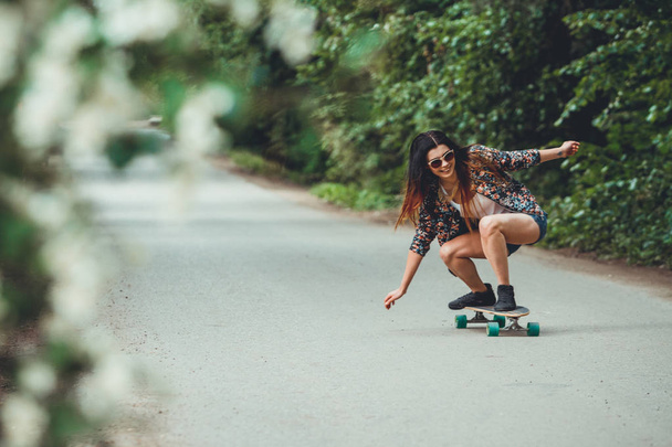 young beautiful fit  woman on skateboard in park - Zdjęcie, obraz