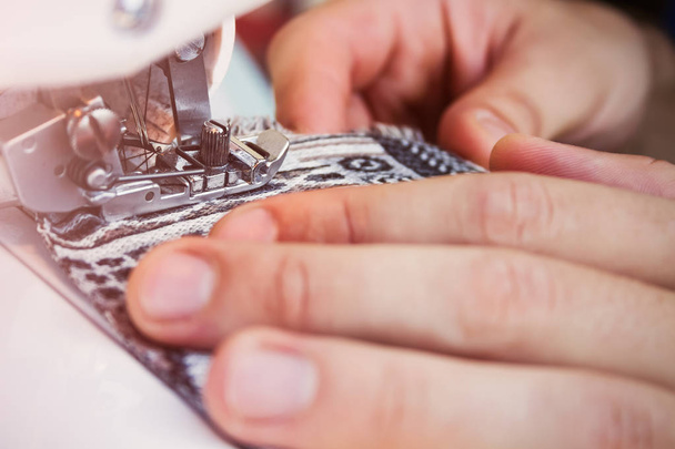 Hands of tailor working on a sewing machine with close up focus on a needle - 写真・画像