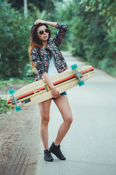 young beautiful fit  woman with  skateboard in park - Фото, зображення