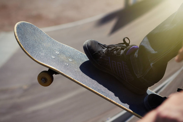 Legs of a female skater on top coping of a ramp ready to roll-in and do tricks - Foto, imagen