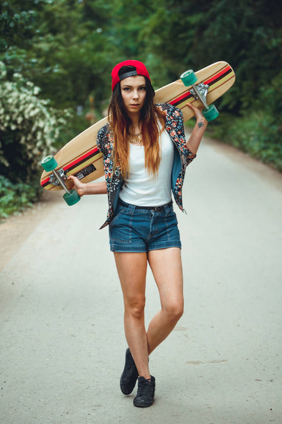 young beautiful fit  woman with  skateboard in park - 写真・画像