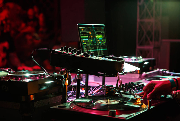 KIEV-4 JULY,2018: Club dj plays music on party with Technics SL-1210 turntables and midi controller connected with Apple Macbook and Traktro software.Professional disc jockey audio equipment on stage - Foto, immagini