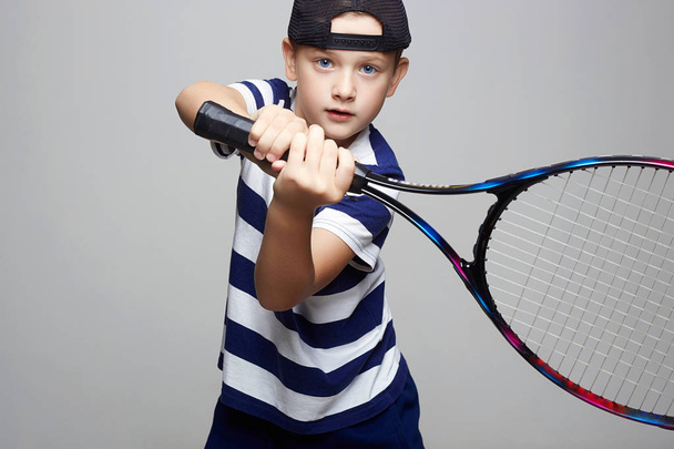 Мальчик играет в теннис. Спортивные дети. Ребенок с теннисной ракеткой
 - Фото, изображение