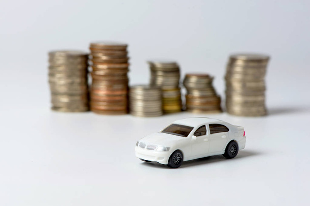 close up view of white toy car and coins on light backdrop - Fotó, kép