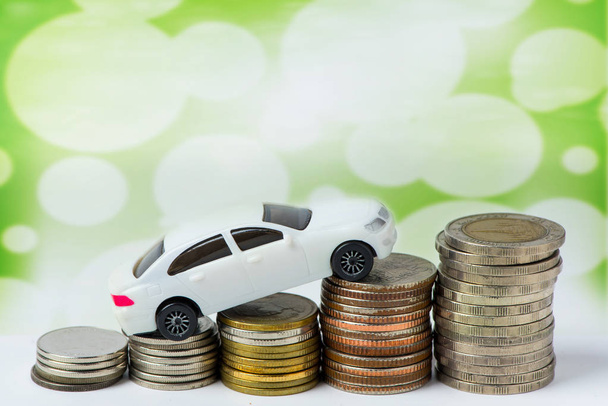 close up view of toy car and coins on green background - Fotó, kép