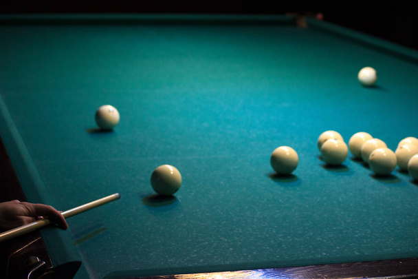 man playing Russian Billiards. the hand holds the cue and has the ball on the green background of the table. put the ball in pocket, win the game. rest, Hobbies, competitions. - Photo, Image