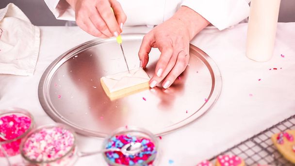 Step by step. Decorating sugar cookies with royal icing and sprinkles for Valentine's day. - Фото, изображение
