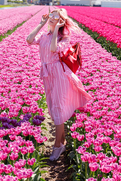Smiling teenage girl walks through tulip field.Holland - Foto, Bild