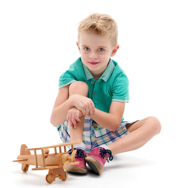 Little boy playing with wooden plane - Фото, изображение