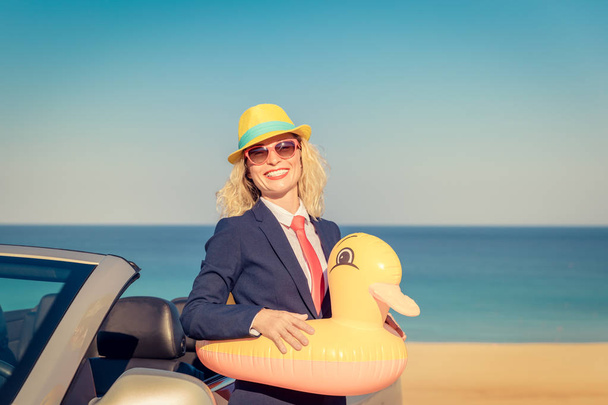 Successful young businesswoman on the beach. Woman standing in the cabriolet classic car. Summer vacations and freedom travel concept - Fotografie, Obrázek