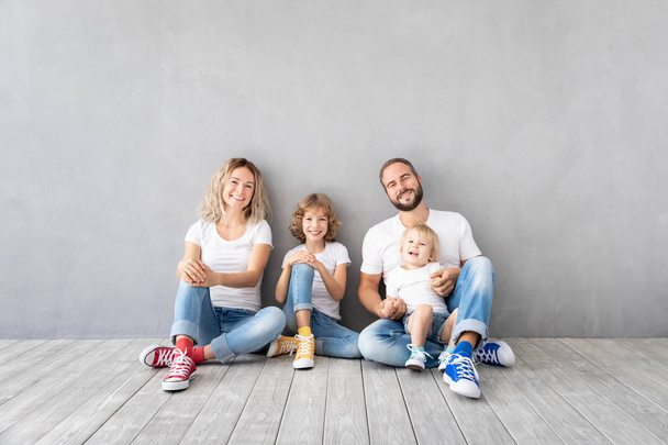 Happy family with two kids playing into new home. Father, mother and children having fun together. Moving house day and real estate concept - Fotoğraf, Görsel