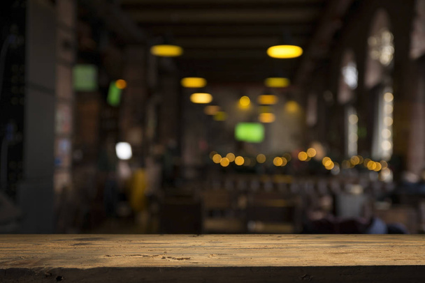 obraz dřevěného stolu před abstraktním rozmazaným pozadím obnovujících světel - Fotografie, Obrázek