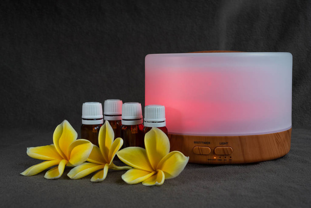 Diffusore di olio essenziale con fiori di frangipani e piccole bottiglie di olio essenziale di vetro
 - Foto, immagini