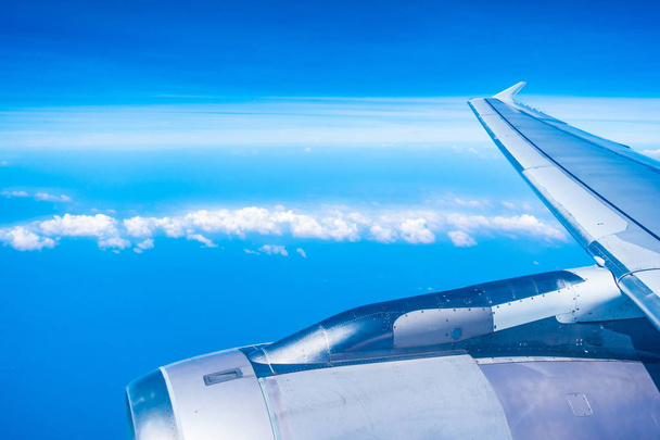 Vue aérienne de l'aile de l'avion avec ciel bleu et nuages blancs
 - Photo, image