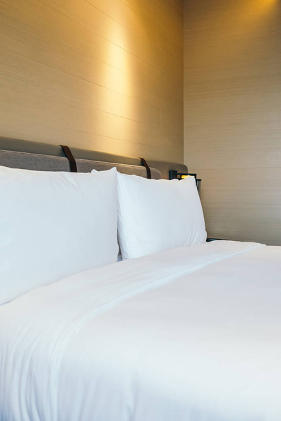Біла зручна подушка на прикрасі ліжка в інтер'єрі готельного ліжка
 - Фото, зображення