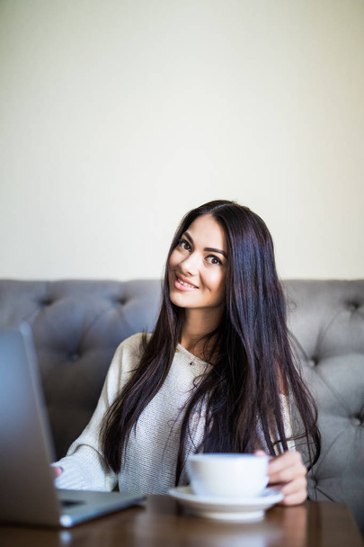 Estudante muito feminino com bonito sorriso teclado algo no laptop enquanto relaxa após palestras na Universidade
. - Foto, Imagem