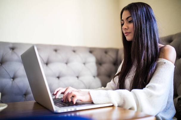 Jeune femme travaillant avec son ordinateur portable et café sur le bureau
 - Photo, image