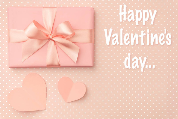 Boldog Valentin-nap-üdvözlőlap díszített rózsaszín jelen box, és papír szív lapos feküdt élő korall színű háttér. Szemközti nézet - Fotó, kép