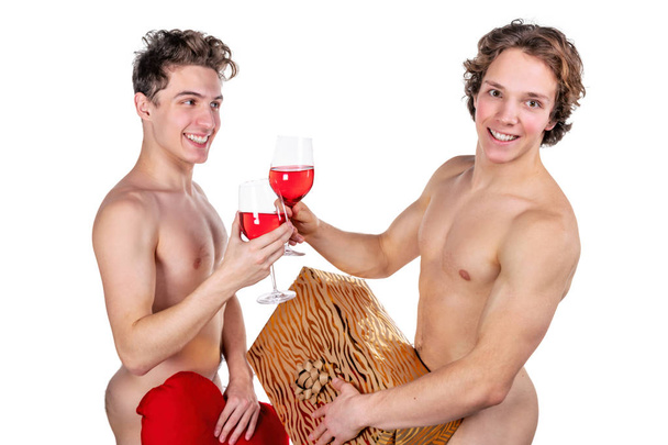 Two funny naked guys holding glasses with red wine and heart isolated on white - Фото, зображення