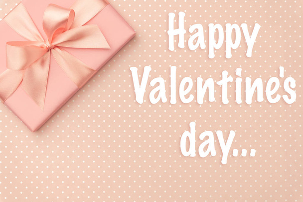 glückliche Valentinstag Grußkarte mit rosa Geschenkbox, Band, Schleife auf lebendigem Korallenhintergrund - Foto, Bild
