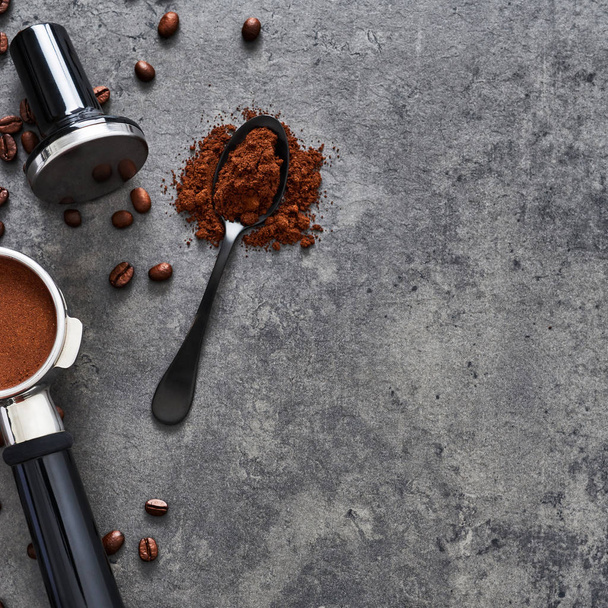 Top view of coffee background. Assorted coffee beans, ground coffee, portafilter and tamper on dark concrete background. Flat lay. Copy space for text. Square crop. Barista concept. - Foto, Bild