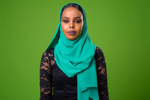 緑の背景にクロマキーに対して若いアフリカのイスラム教徒の女性 - 写真・画像