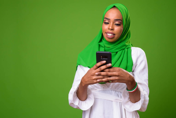 Young African Muslim woman against chroma key with green background - Foto, imagen