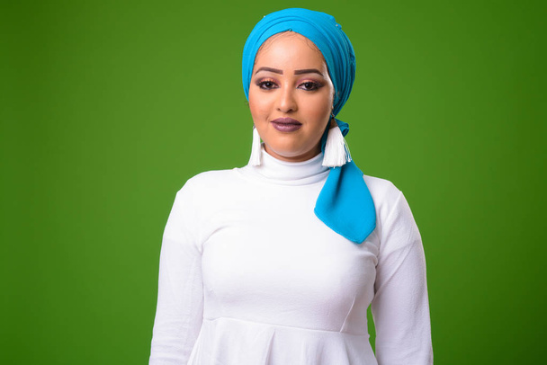 緑の背景にクロマキーに対して若いアフリカのイスラム教徒の女性 - 写真・画像